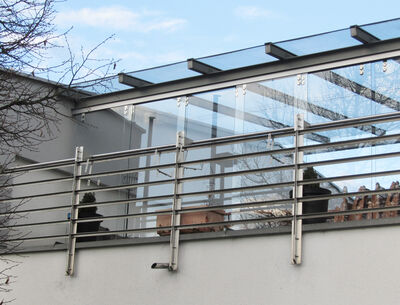 Terrasse mit Glasüberdachung und Metallgeländer