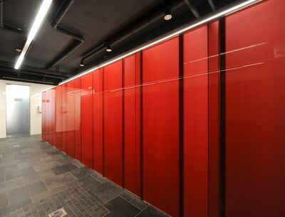 Großes öffentliches WC, das mit roten Glaskabinen ausgestattet wurde