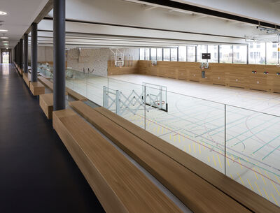 Innenansicht einer modernen Sporthalle mit Glasgeländern 